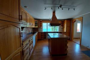 a kitchen with wooden cabinets and a large island at A quiet and a relaxing place to stay in Mittet