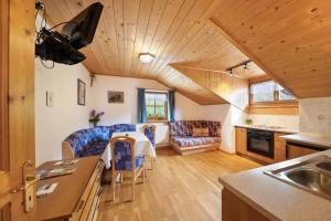 cocina y sala de estar con sofá y mesa en Wieserhof Ferienwohnung Zirm en Sarntal