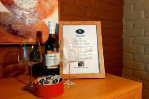 a bottle of wine and two glasses on a table at Sunset Balcony Bass Coast Beach House in Grantville +53 photos