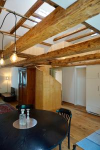 a dining room with a table and chairs and wooden ceilings at Beeindruckende Wohnung im Rheintal in Götzis