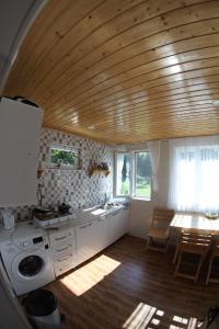a kitchen with white cabinets and a wooden ceiling at NOVEL HOUSE in Martvili