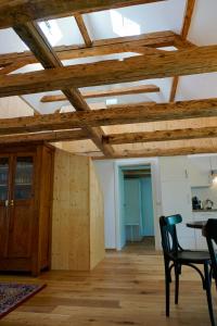 a room with wooden ceilings and a table and chairs at Beeindruckende Wohnung im Rheintal in Götzis