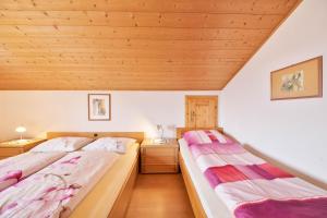 2 camas en una habitación con techos de madera en Wieserhof Ferienwohnung Priml en Sarntal