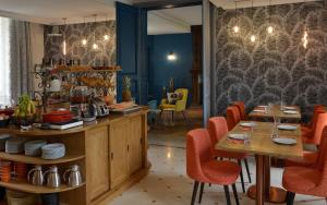 a restaurant with wooden tables and red chairs at Château Saint Gilles in Bayeux