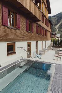 a house with a swimming pool next to a building at Hotel Gasthof Adler in Schoppernau