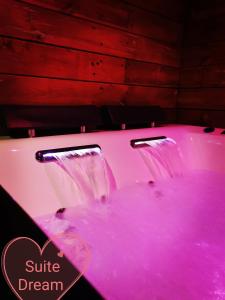 a pink bathtub with a pink dye in it at Faranel in Berlaimont