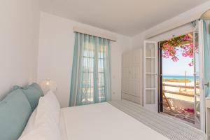 a bedroom with a bed and a door to the beach at Studios Strouvalis in Agiassos