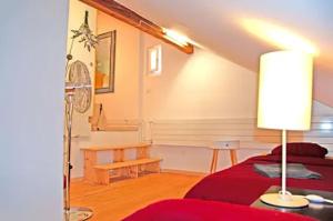 a bedroom with a red bed and a lamp at Zurich Airport Apartment Loft 45m2 free Parking, Airport Drive Service, separate Kitchen in Kloten