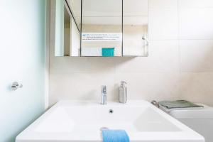 a white bathroom with a sink and a mirror at Zurich Airport Apartment Loft 45m2 free Parking, Airport Drive Service, separate Kitchen in Kloten