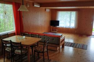ein Wohnzimmer mit einem Tisch und einem Sofa in der Unterkunft Cotteg Marjakallio (BerryRock) in Punkaharju