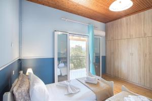 a bedroom with a bed and a large window at Olive Tree House in Evropoúloi