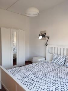 a white bedroom with a large bed with a lamp at Vale do Sol in Albufeira