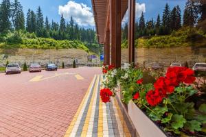 a balcony with red flowers and a parking lot at Villa Victoria in Bukovel