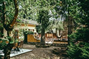 een tuin met stoelen en bomen voor een gebouw bij Landhotel Classic in Wensickendorf