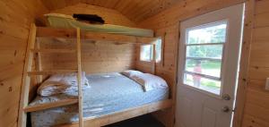 een slaapkamer met een stapelbed in een blokhut bij Trent River Cottages in Hastings