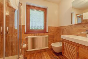 een badkamer met een wastafel en een toilet en een raam bij CASA JASMIN - Scopri le bellezze di Courmayeur - COUR 0154 in Courmayeur