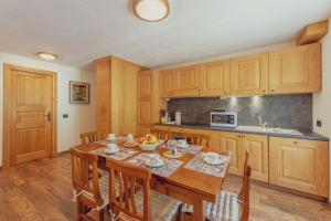 een keuken met een houten tafel en houten kasten bij CASA JASMIN - Scopri le bellezze di Courmayeur - COUR 0154 in Courmayeur