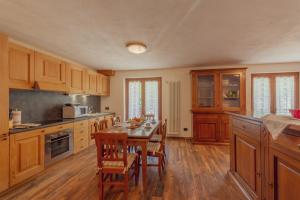 een keuken met houten kasten en een tafel met stoelen bij CASA JASMIN - Scopri le bellezze di Courmayeur - COUR 0154 in Courmayeur +28 foto's