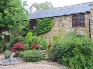 an old stone house with a garden in front of it at Church Villa B & B in Chesterfield