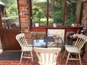 a glass table and chairs on a patio at Church Villa B&B in Chesterfield