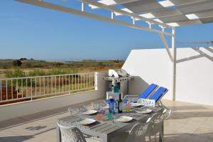 a table and chairs on a balcony with a view at Praia Dria in Armação de Pêra
