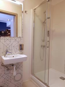 a bathroom with a sink and a shower at Hostel Annamarie in Szczecin