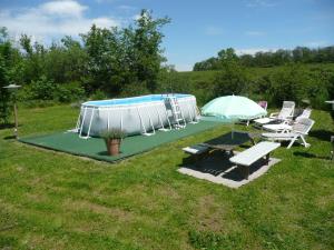 a pool with a table and two chairs and an umbrella at Grootgenoegen in Bourbon-lʼArchambault