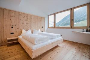 a bedroom with two beds and a large window at Ausserwegerhof in Anterselva di Mezzo