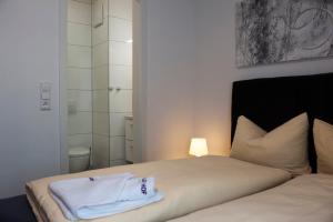 a bedroom with a bed with a white towel on it at Wiesentäler Hof Hotel garni in Konstanz