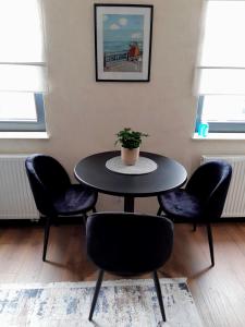 a table with four chairs and a potted plant on it at Apartament w Centrum in Zamość