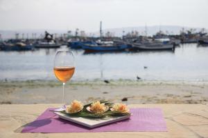 a glass of wine and flowers on a table at Bamboo Lodge Paracas in Paracas