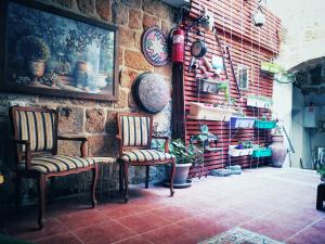 une chambre avec deux chaises et un mur en briques dans l'établissement Shafika house, à Acre