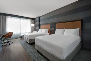 a hotel room with two beds and a desk at Holiday Inn Express - Houston - Galleria Area by IHG in Houston