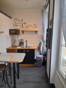 a small kitchen with a sink and a table at Le Samwest in Arromanches-les-Bains