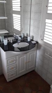 a bathroom with a sink and a black counter at Villa des Châteaux in Saint-François