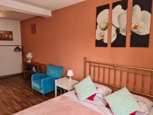 um quarto com uma cama e uma cadeira azul em Luca's studio 3 ,Close to Therme Bucharest, Airport Otopeni em Balotesti