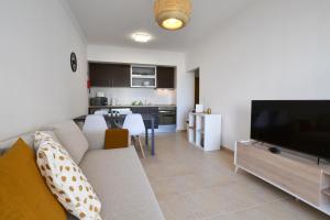 uma sala de estar com um sofá e uma televisão de ecrã plano em Top Refuge by ALgest em Portimão