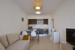 a living room with a couch and a kitchen at Top Refuge by ALgest in Portimão