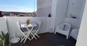 a balcony with a table and two chairs and a table and a chair at House with a view in Alcácer do Sal