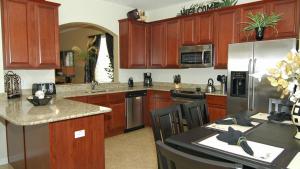 a kitchen with wooden cabinets and stainless steel appliances at The Ultimate Villa on Windsor Hills Resort, Orlando Villa 4768 in Orlando