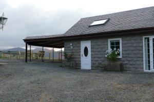 a small stone house with a white door and a roof at The Annexe at Loch View Farm in Crieff