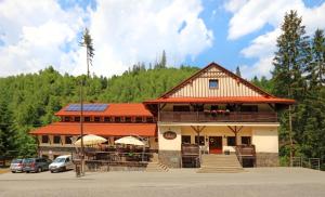 a large building with a porch and a roof at Penzión Solisko*** Oščadnica in Oščadnica