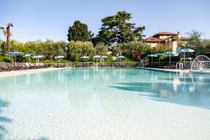 a large swimming pool with chairs and umbrellas at Hotel Villa Maria in Desenzano del Garda