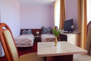 Pokój z 2 łóżkami i stołem z telewizorem w obiekcie Hotel Aleksander w Ustce