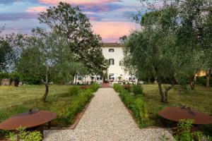 a garden with two benches and a building at Hotel Villa San Michele in Lucca