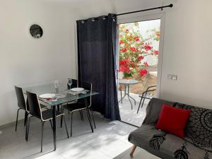 - un salon avec une table, des chaises et un canapé dans l'établissement La dama gris - Fuerteventura Holiday Wi-Fi, à Costa de Antigua