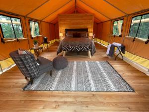 ein Schlafzimmer in einem Zelt mit einem Bett und einem Teppich in der Unterkunft Naturluxe & Stars in Watkins Glen