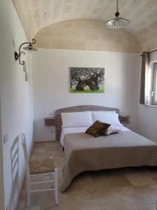 1 dormitorio con 1 cama y 1 silla en Masseria Signora Cecca, en Fasano
