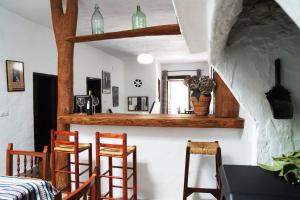 a dining room with a table and chairs and a counter at Casa Rural Vata Pampaneira Alpujarra in Pampaneira
