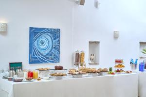 a buffet with food on a white table at Paolas Τown Boutique Hotel in Mikonos